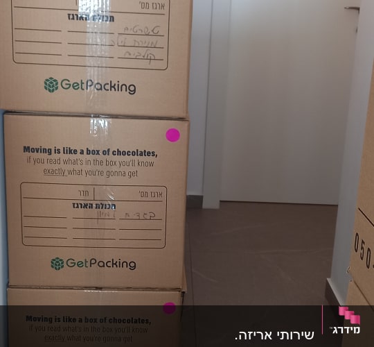 שלושה ארגזי קרטון עם מדבקות ורודות במסדרון